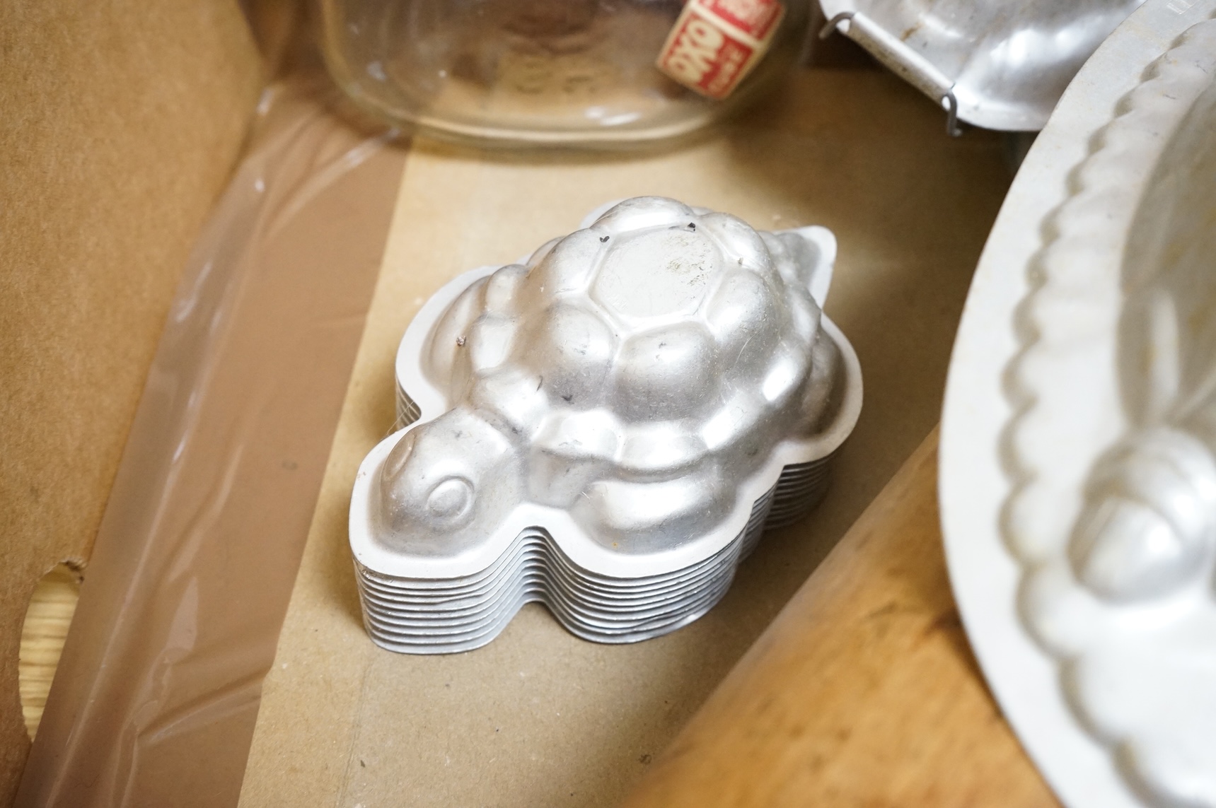 A collection of Kitchenalia, including a Wade novelty teapot, a large wooden rolling pin, jelly moulds, etc.